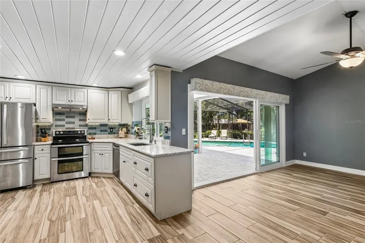 Beautifully renovated kitchen with ship lap ceilings, soft close 42 inch cabinets, glass back splash, new appliances new floors, pass through to the lanai, and quartz countertops.  View into the family room