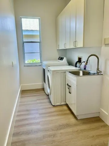 Large laundry room with cabinets, sink