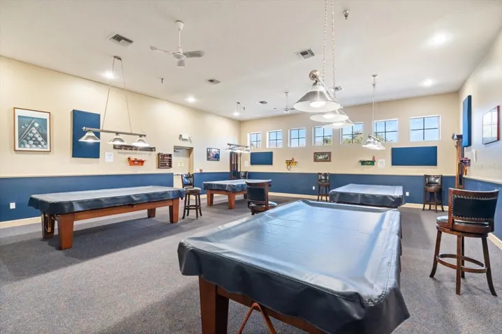 Enjoy friendly competition in the community game room featuring billiards and recreation areas.