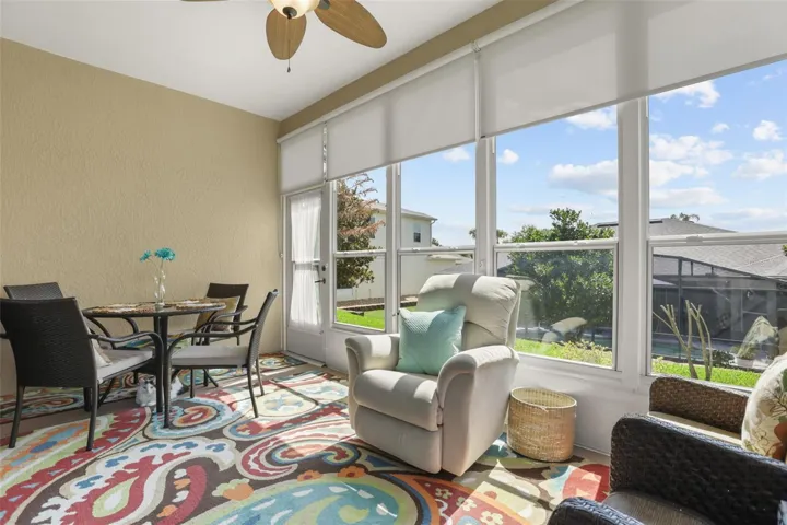 Bright enclosed Florida room with expansive windows that bring the outdoors in and create the perfect place to relax year-round.