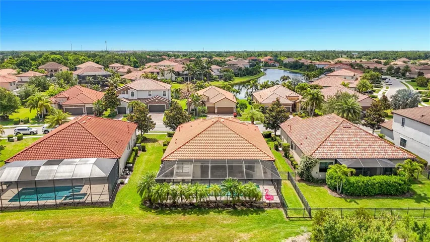 Center home is the rear view of this lovely property with tropical palms surrounding the pool cage.