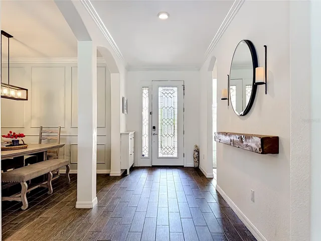 Decorative Glass front door with sidelight, opens into a spacious foyer.