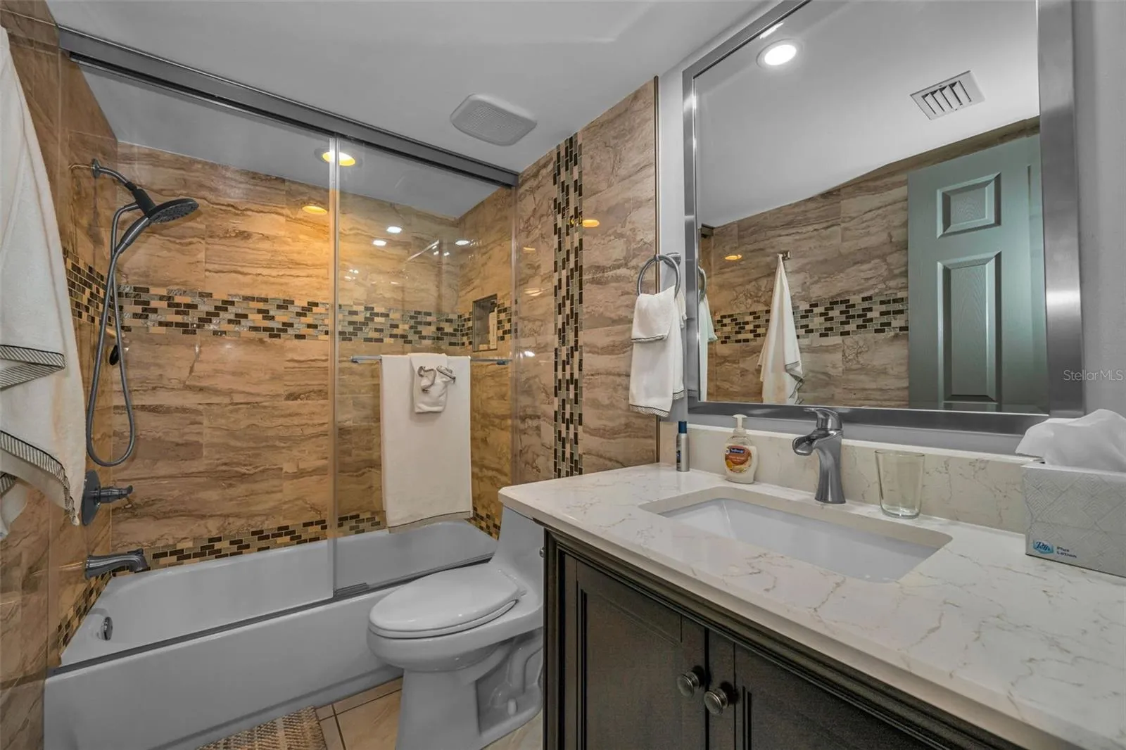 New vanity, tub tile, glass doors, exhaust in this Bathroom.