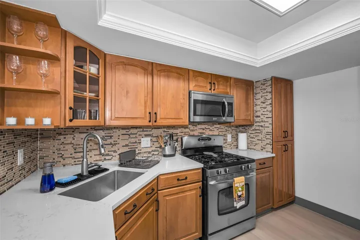 Kitchen with gas range, microwave, new backsplash, new Quartzite counter, sink & faucet!