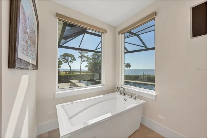 Her Primary Bath with Expansive Bay View