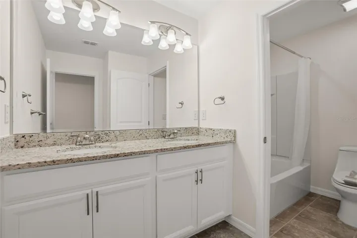 Secondary full bath with  granite, vanities, new faucets, fixtures, and soft close cabinets