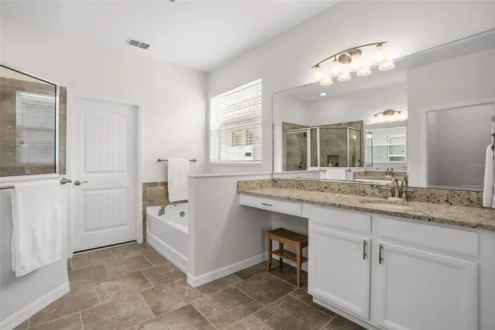 Primary En Suite with granite counters, soft close wood cabinets, new fixtures, faucets and door hardware, double vanity, soaking tub and tiles shower. This owner also added some much needed towel bars