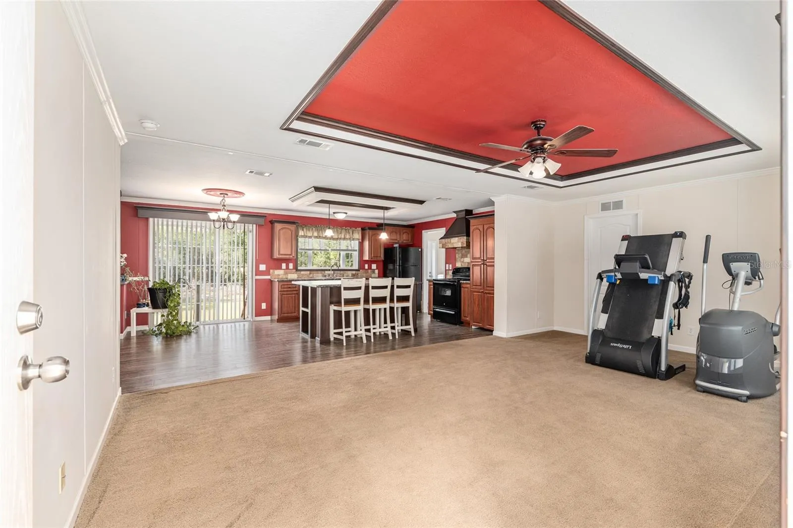 Living room w/ tray ceiling and the kitchen beyond
