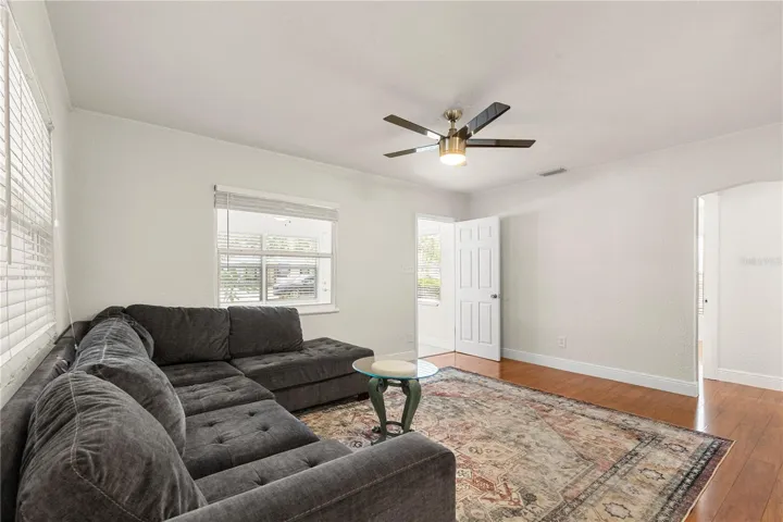Living room with access to sun room and hallway to bathroom and two bedrooms