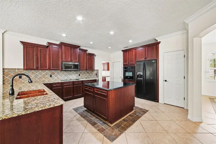 Open kitchen with loads of granite counter space, granite island, and breakfast bar.