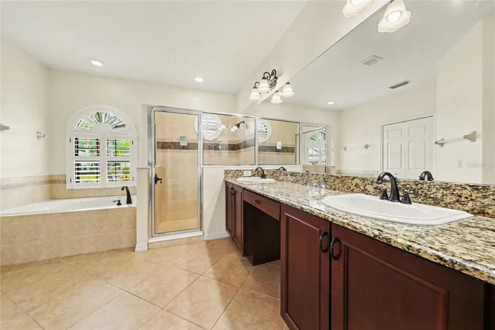 Primary Bath with double-granite vanities, walk-in shower, and jetted tub.