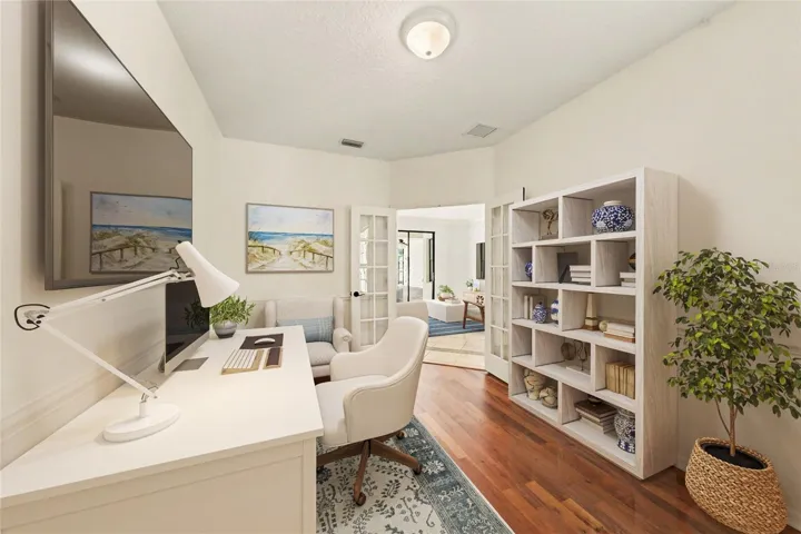 Office with French doors and hardwood flooring.
