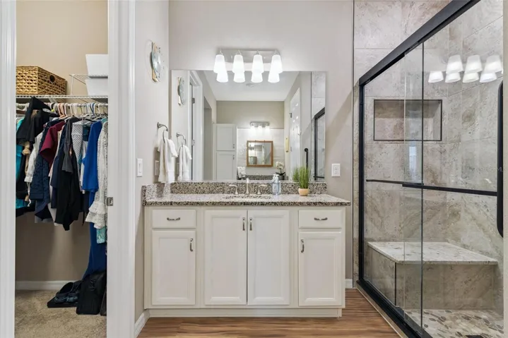 The bath was upgraded to 2 separate granite topped vanities and shower was remodeled adding custom tile with shower seat and glass sliders.