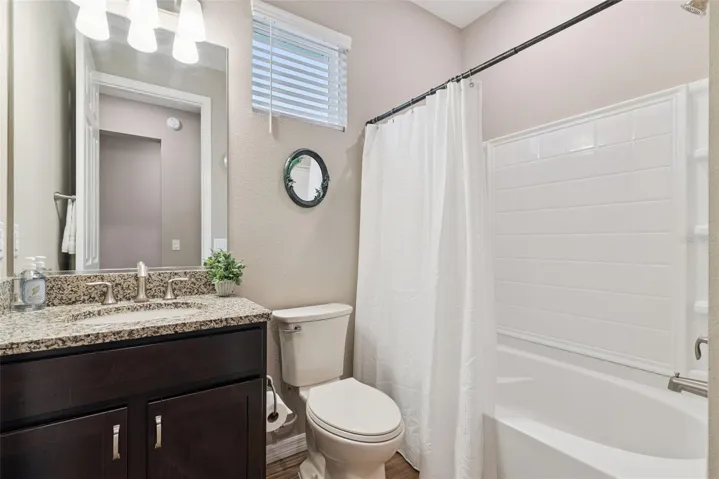 Secondary/Guest Bath with oversized tub/shower and granite topped vanity. This bath was remodeled as well with new sink and matching comfort height toilet. An additional linen closet lies just outside the bath in the guest hall.