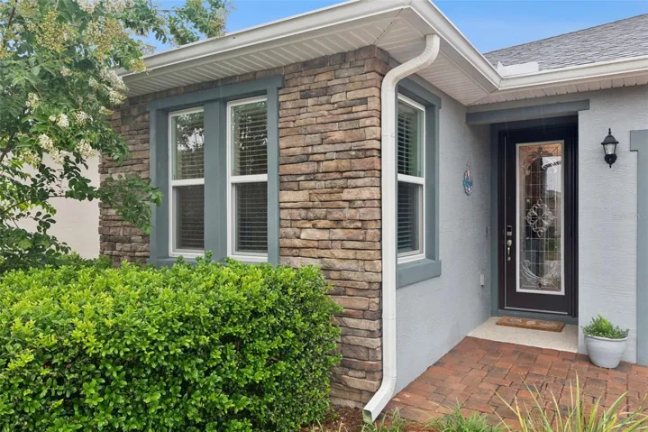 The seller opted to upgrade the Stone accent on the entire front of this villa and added a stained glass insert to the front door for privacy. Step on in!