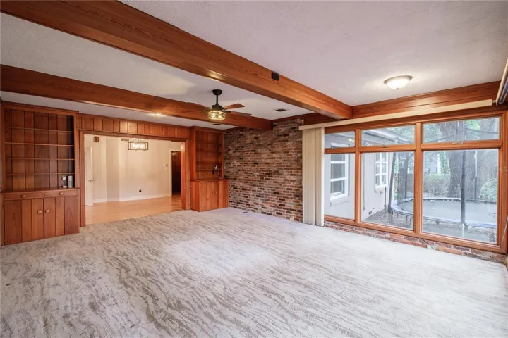 Family room with features built-ins and ceiling beams