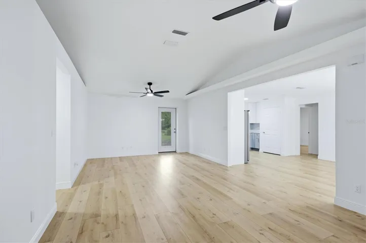Vaulted ceilings with plant shelves adorn each side of the living area.