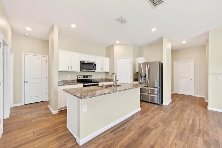 The chef’s kitchen features UPGRADED GRANITE countertops, desirable shaker-style cabinetry, STAINLESS STEEL APPLIANCES, pantry storage, and a large ISLAND with casual bar seating at the heart of the home.