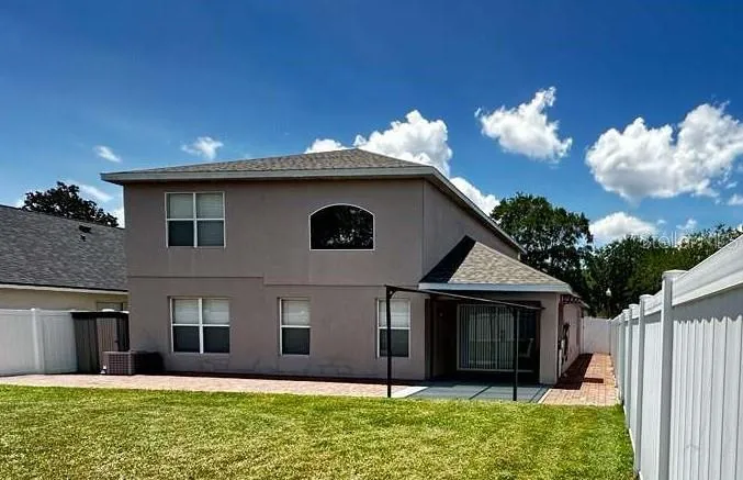 BACK VIEW WITH A SHED ON THE LEFT AND PATIO ON THE RIGHT.