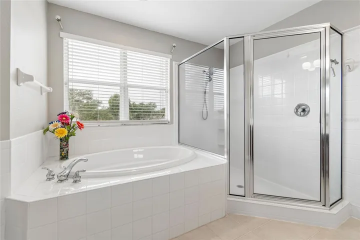 The spacious ensuite bathroom boasts plenty of natural light, garden tub, huge shower, double vanity and double closets