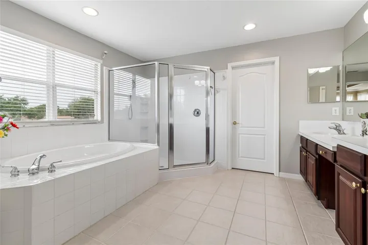 The spacious ensuite bathroom boasts plenty of natural light, garden tub, huge shower, double vanity and double closets
