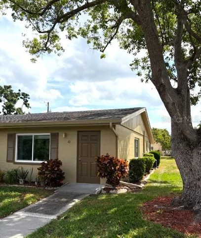 Canton Court #62, situated on a beautiful courtyard with lovely landscape, old Florida trees, and a spacious view.