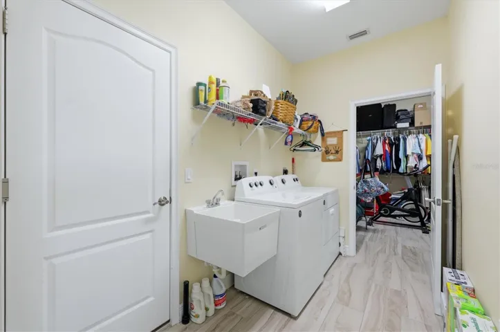 Laundry room off the primary closet and door to the garage
