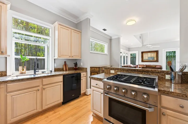 The spacious Kitchen is a standout with 42-inch cabinetry, granite countertops, a HIGH-END THOR GAS RANGE, NEW WHIRLPOOL REFRIGERATOR, breakfast bar seating, and a closet pantry, combining luxury with functionality.