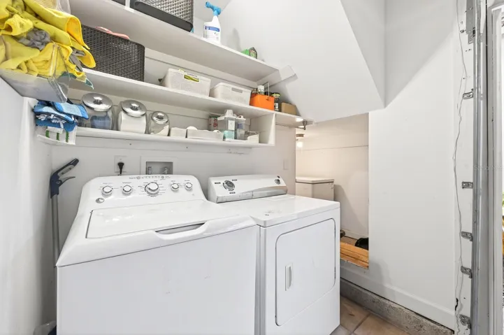 The washer, dryer, and additional storage shelving are conveniently located in the garage.