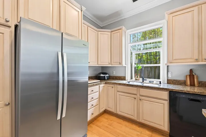 The spacious Kitchen is a standout with 42-inch cabinetry, granite countertops, a HIGH-END THOR GAS RANGE, NEW WHIRLPOOL REFRIGERATOR, breakfast bar seating, and a closet pantry, combining luxury with functionality.
