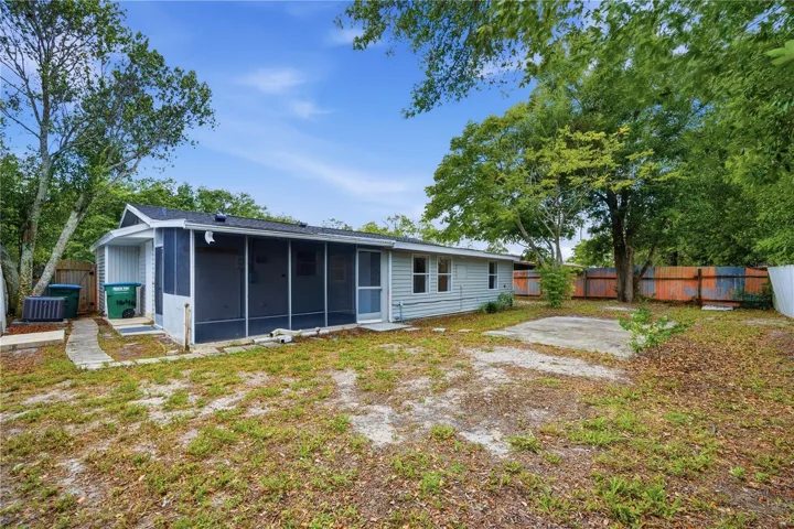 Fenced backyard has a concrete pad as well
