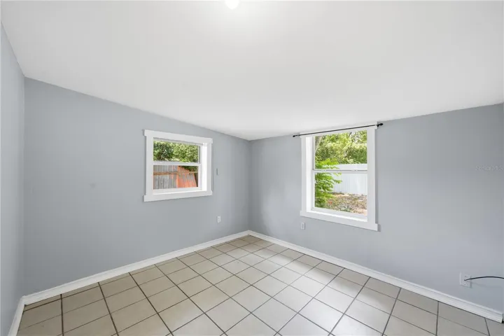 This well-appointed bedroom, located at the rear of the property, boasts delightful backyard views, creating a serene and inviting space. Its convenient placement directly off the den enhances the home's flow and functionality,