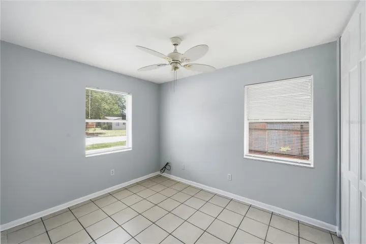 Bedroom on the front corner of the house with double length closet, tile floors and next to full bathroom