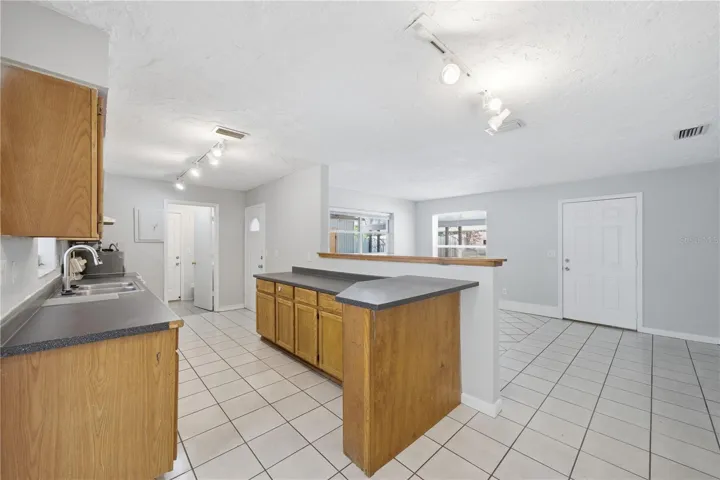 Located at the end of the kitchen is a utility room that includes space for a stackable washer and dryer and also includes a full bathroom