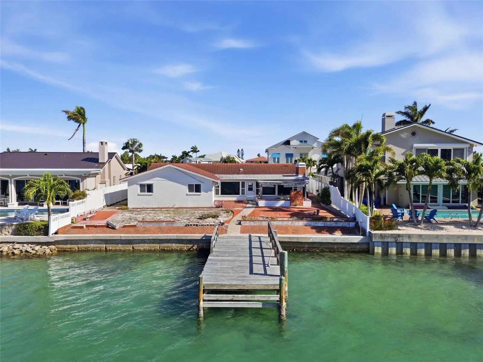 Drone photo of the back of 4 Bellevue looking north at the seawall, dock and rear of the home.