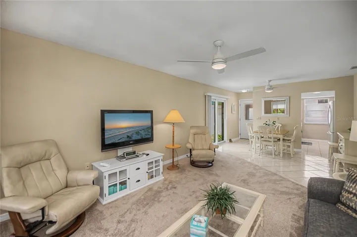 This view is from the lanai end of the living room showing the dining area and kitchen entrance.