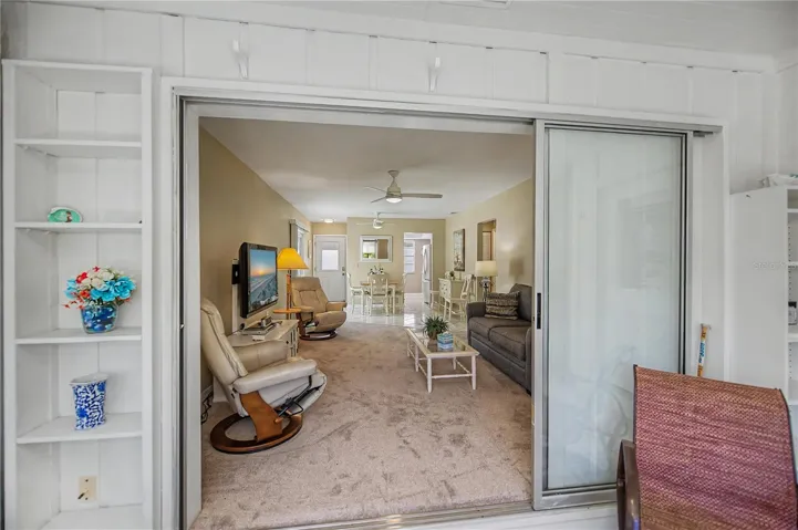 Patio doors off living room open onto a spacious lanai overlooking green space.