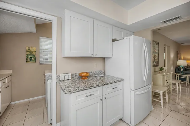The other side of the kitchen showing entrance to laundry room to the left and then the entrance to dining area on right  More counters and cabinets.