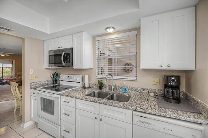 Window over sink lets in natural light - plentry of cabinets, drawers and counter space