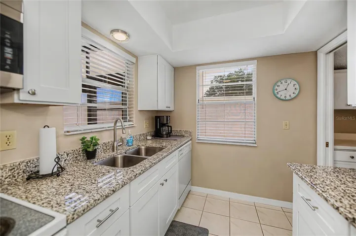 Updated kitchen with wood cabinetry and granite counter tops.