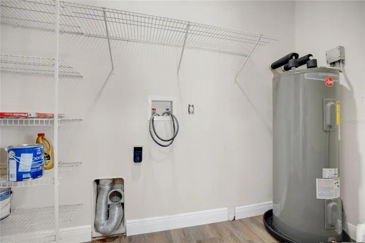 Inside laundry with room for full size machines and new water heater.