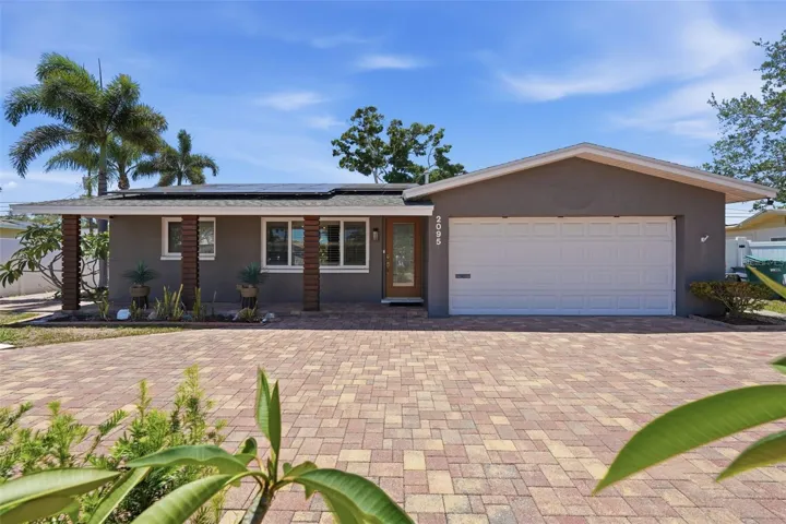Bold curb appeal with an oversized paver driveway makes a statement before you even walk through the door.