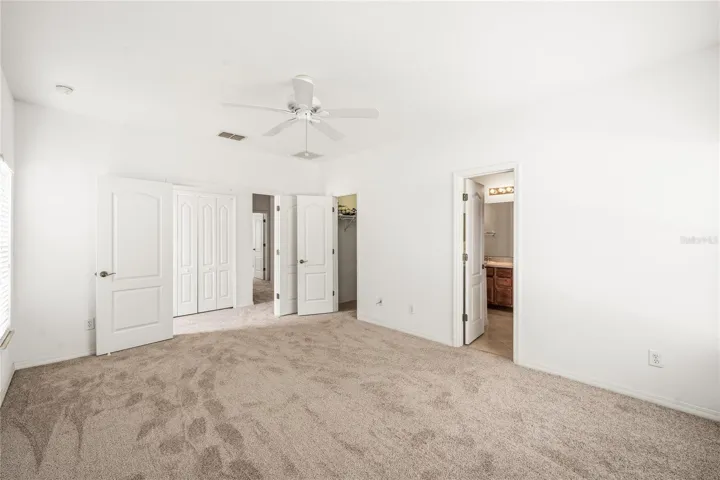 Spacious primary bedroom is 16 x 12 with French door entry and ensuite bath with dual sink vanity, garden tub, step-in shower and walk-in closet