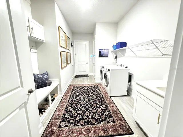 Laundry romm has stunning drop zone, a big closet, and a sink with cabinet.
