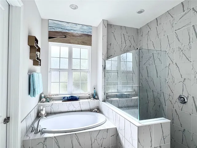 Primary Bath ensuite with soaking tub, frameless shower for two, and double vanities.