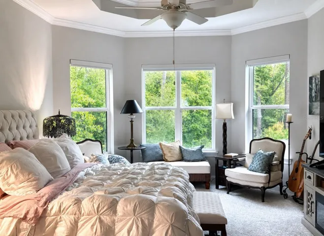 Primary bedroom with large sitting area with bay window, double tray 16' coffered ceiling and 14' ceilings through out the house.