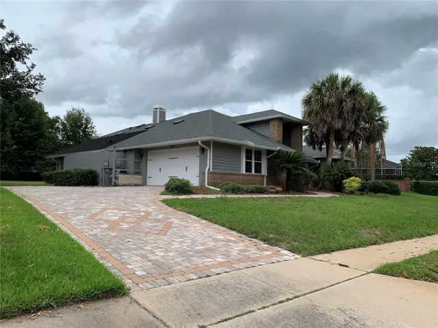 2 car garage with paver driveway and extra parking space that extends beyond the garage   Home also has solar hot water panels for the pool on the roof.