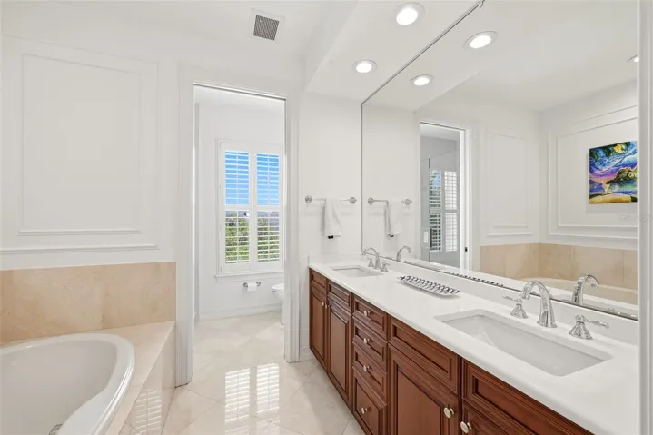 Primary Bath With New Updated Quartz Vanities with Plumbing fixtures, Marble Floors and Bath tiles