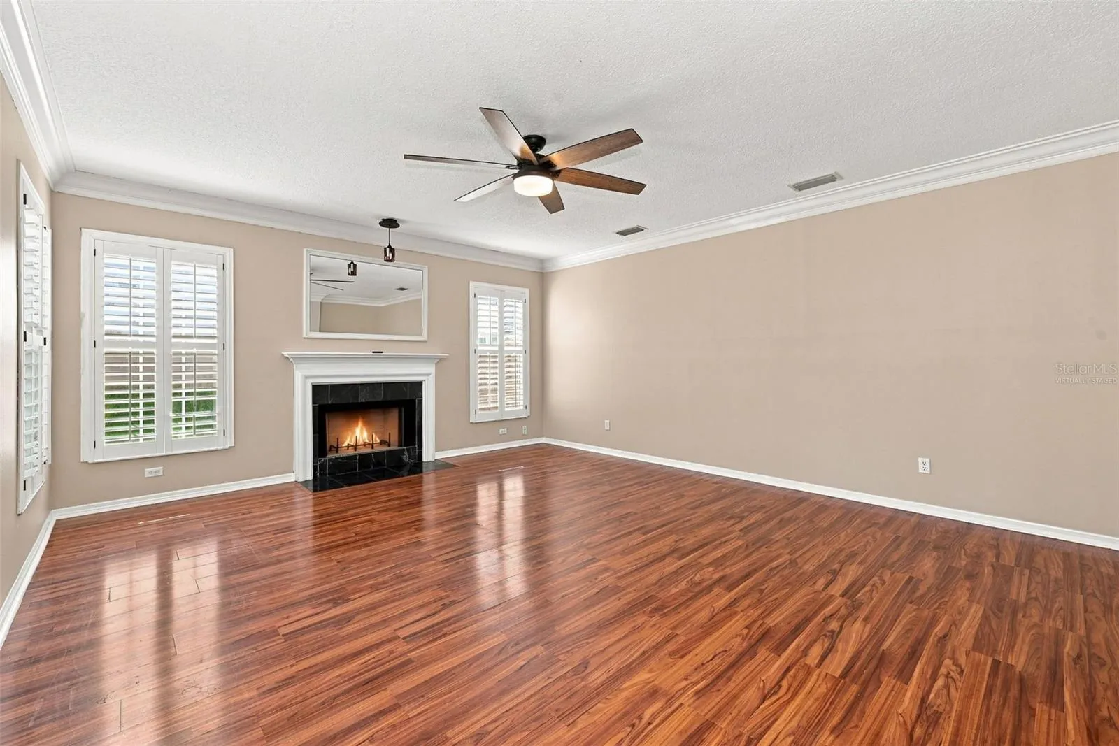 Formal Living Room with wood burning fireplace, crown molding and plantation shutters