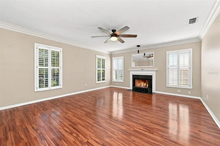 Formal Living Room with wood burning fireplace, crown molding and plantation shutters